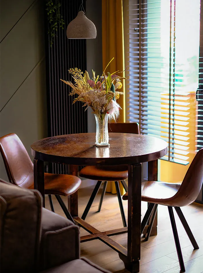 Round table with a flower vase and chairs