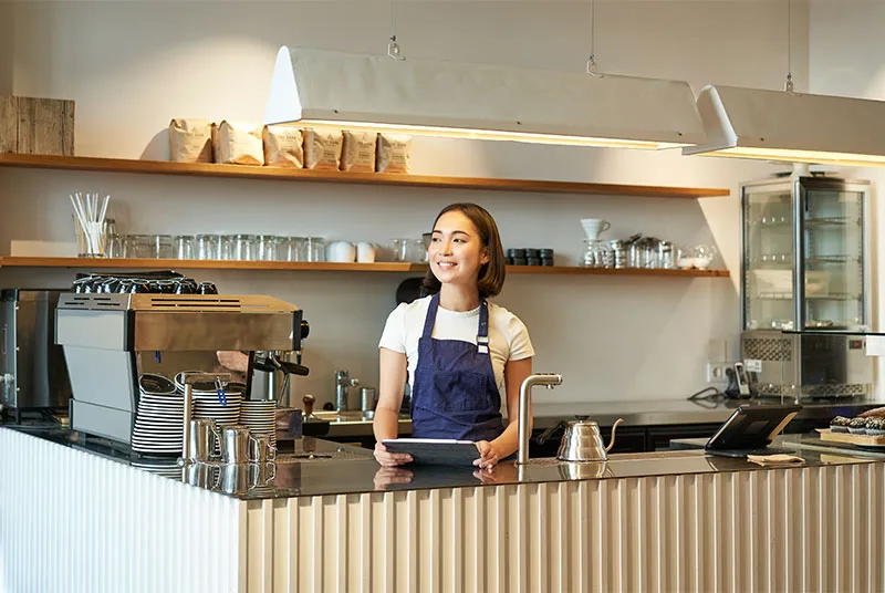 Barista at the café counter using tablet