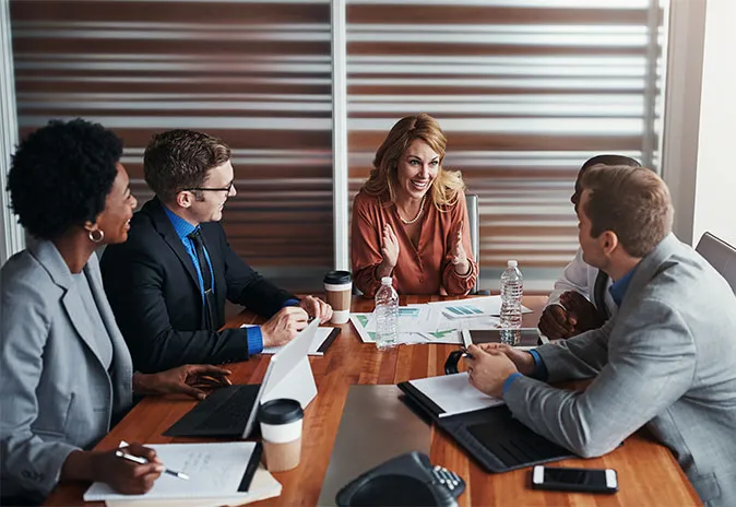 5 people sitting at a meeting room table